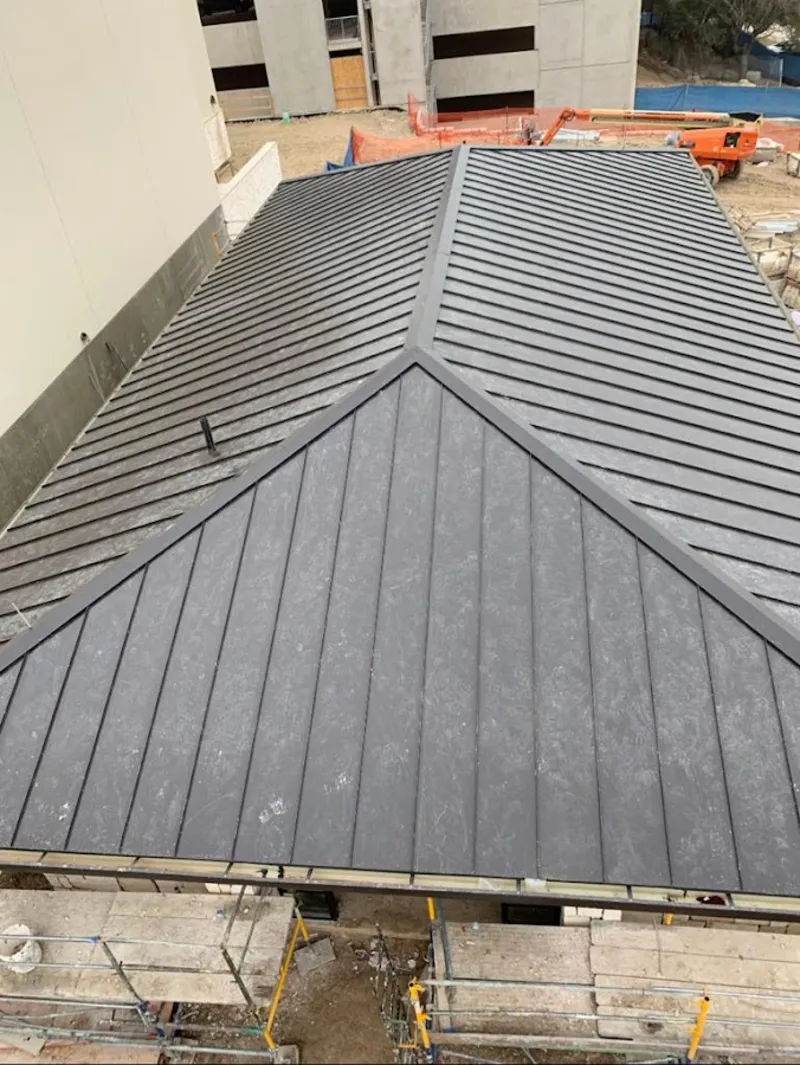 Commercial metal roof construction with crane equipment in Claverack